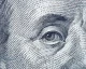 Close-up of Benjamin Franklin's eye from a US $100 bill showing the detailed engraving lines and dots.