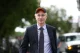 Palantir CEO Alex Karp walking outdoors wearing a cap