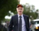 Palantir CEO Alex Karp walking outdoors wearing a cap
