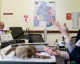 Election workers at a polling site with a congressional district map on the wall