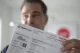 Man holding up an Xcel Energy utility bill