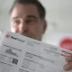 Man holding up an Xcel Energy utility bill